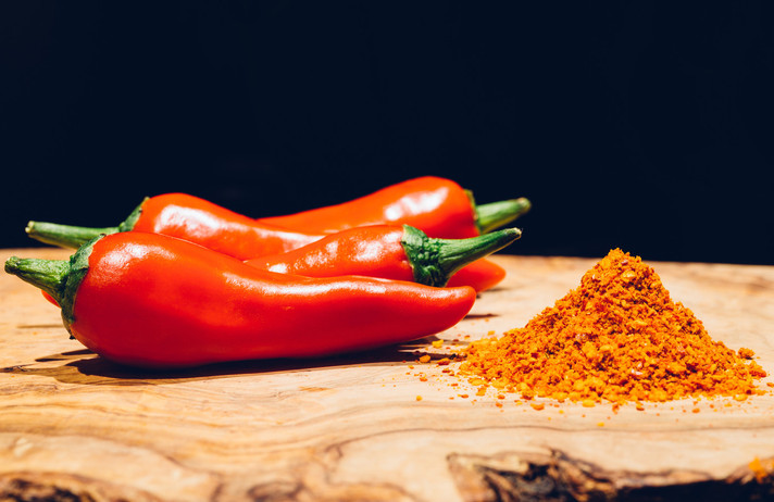 Close up of espelette peppers, fresh and powdered